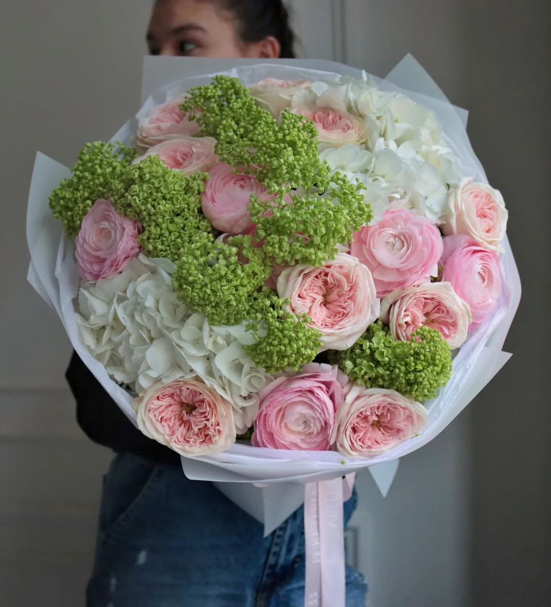Şaftalı bağ qızılgülləri, çəhrayı ranunkulus və yaşıl giləzəhər