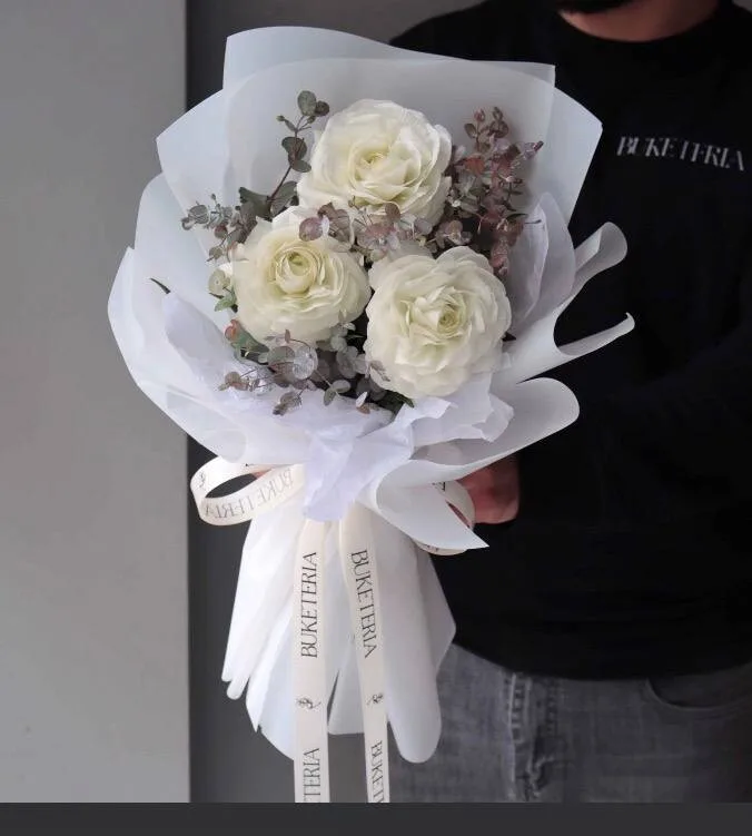 Üç ağ ranunkulus su keçirməz kağızda