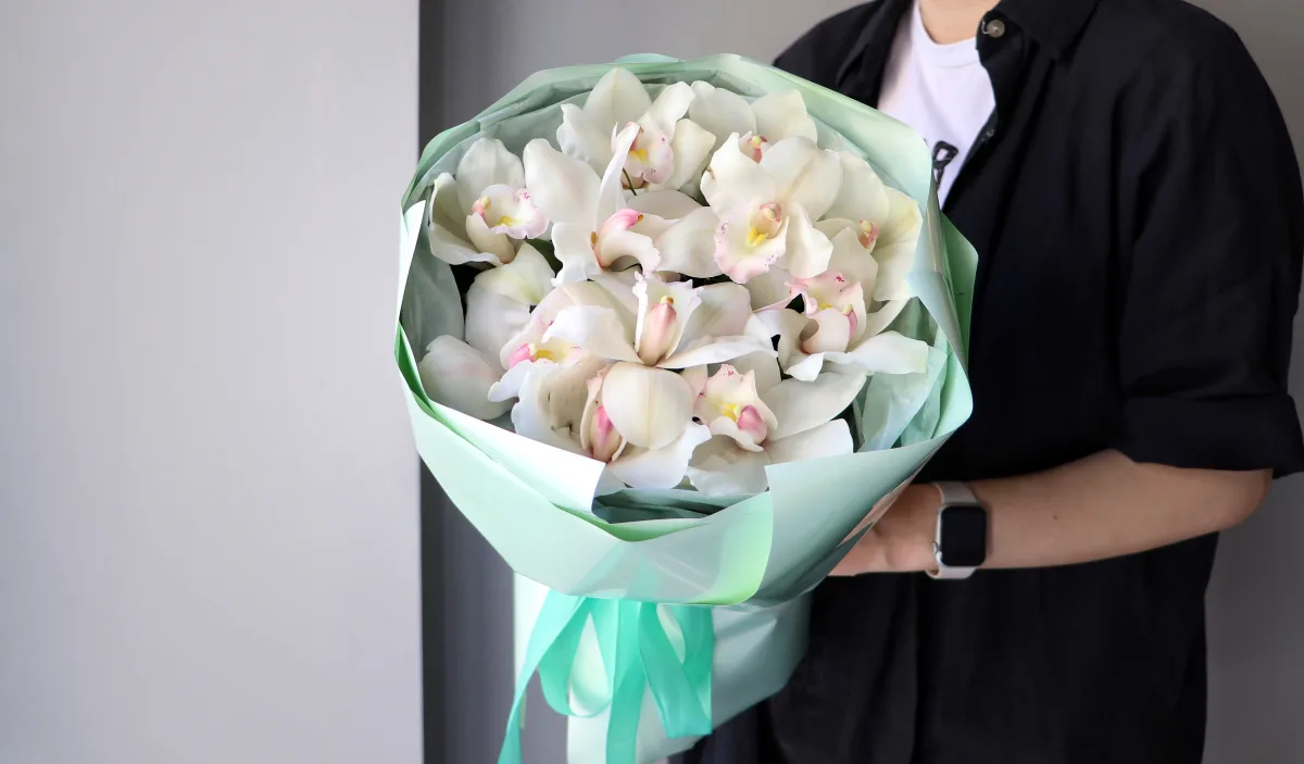 On bir ağ və çəhrayı simbidium orkideyası su keçirməz kağızda
